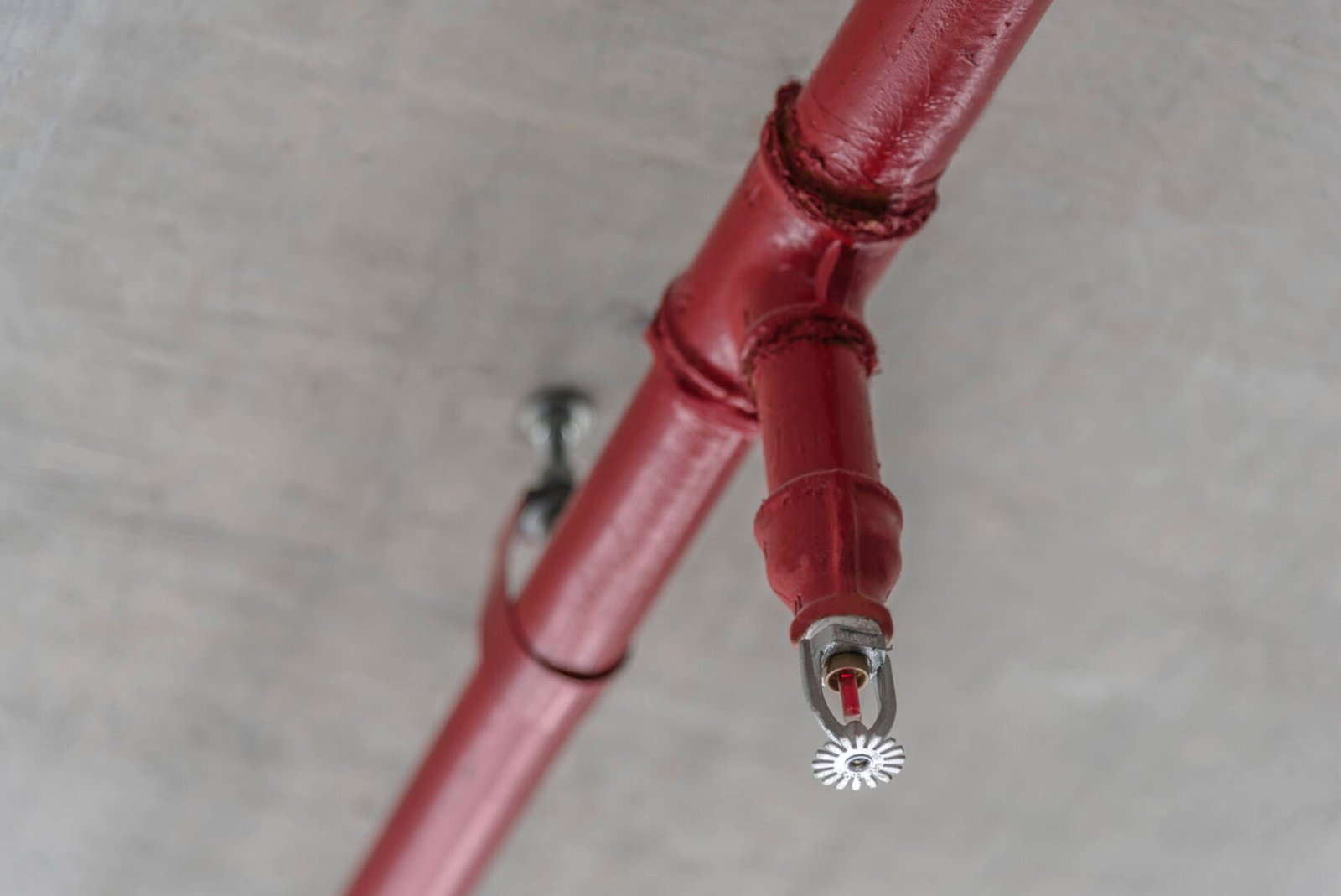 Red fire sprinkler on ceiling