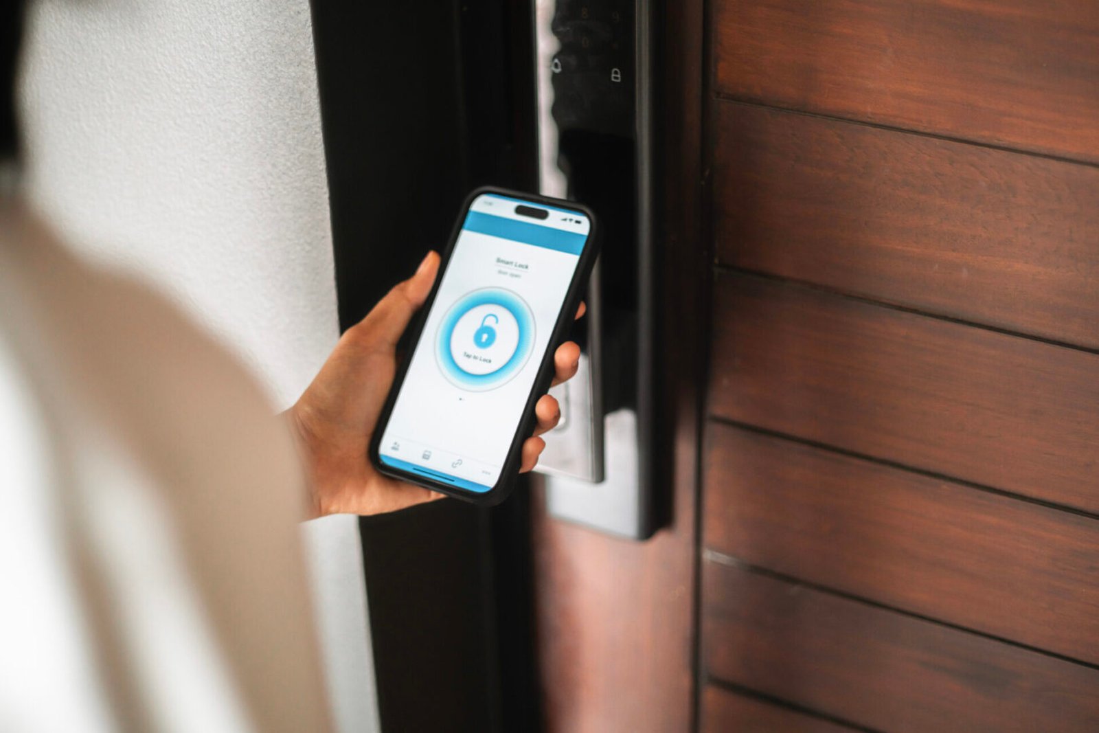 Hand holding phone near digital lock