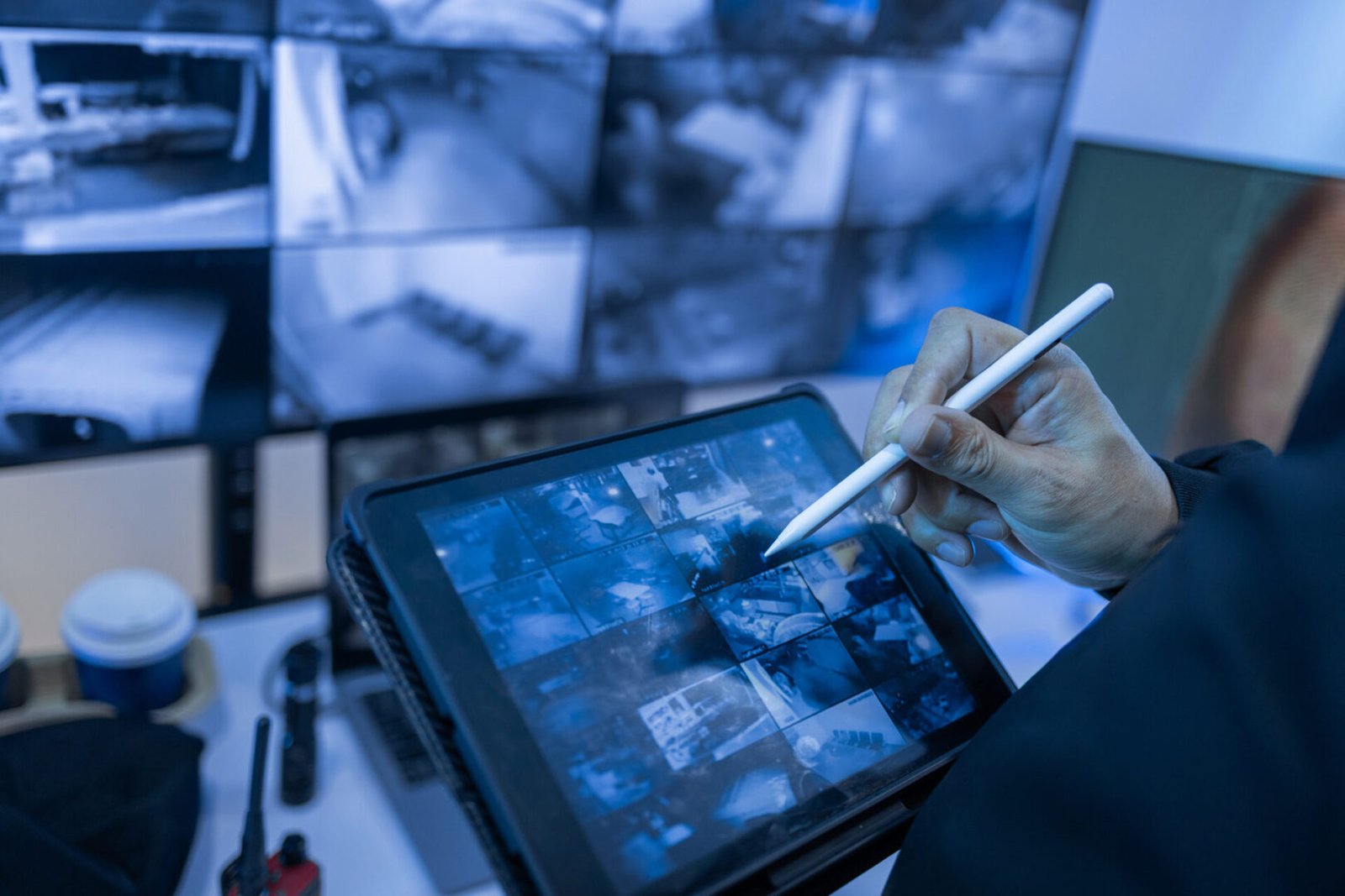 Hand holding stylus on surveillance screen