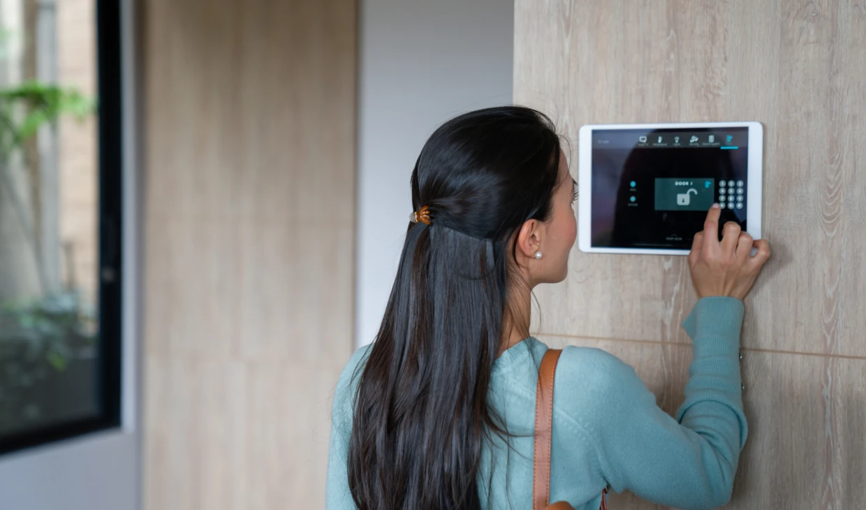 User operating smart home interface on wall.