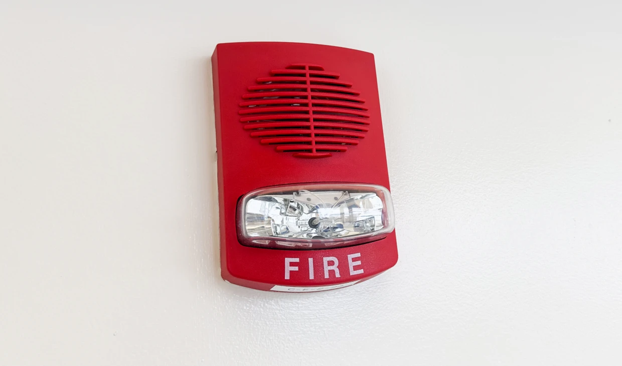 Red fire alarm on white wall