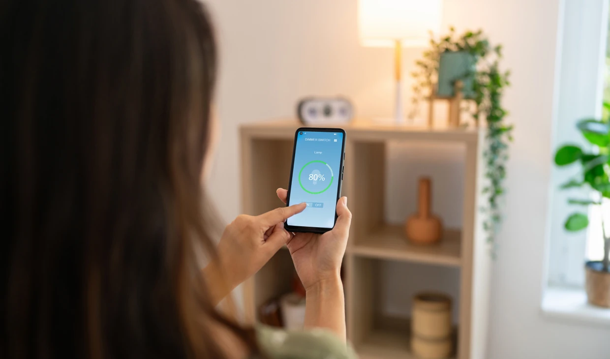 Woman using smartphone to control device