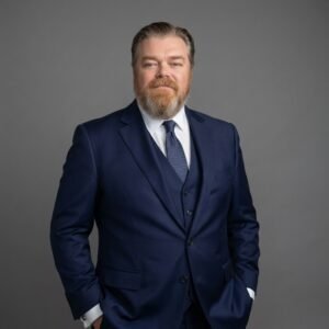 Man in blue suit with beard.